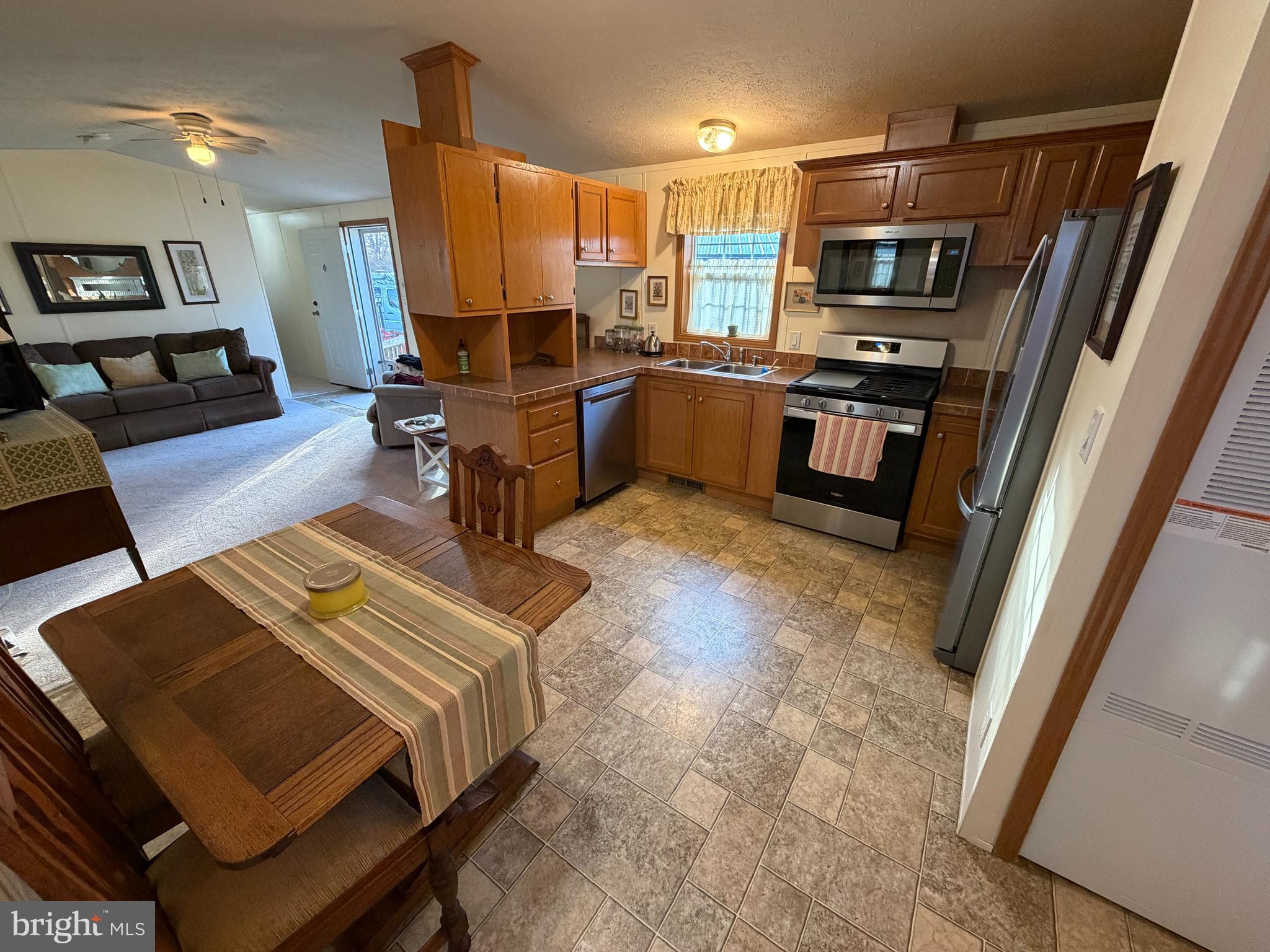 110 Dawn Street Quarryville, PA 17566 - Photo 16 of 29 a living room with stainless steel appliances furniture a rug and a view of kitchen