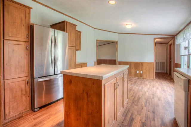 a kitchen with stainless steel appliances a refrigerator and wooden floor