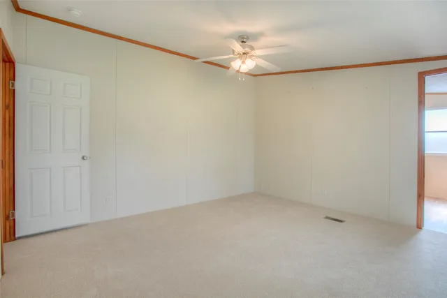 an empty room with a chandelier fan