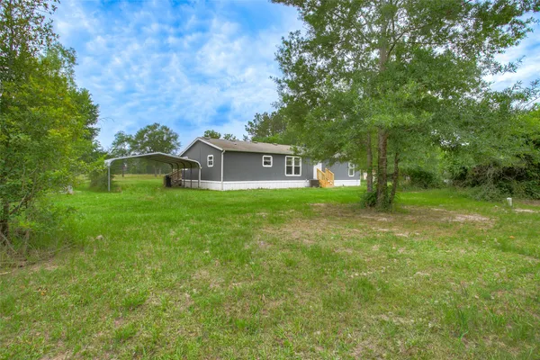 a view of a house with a yard and sitting area