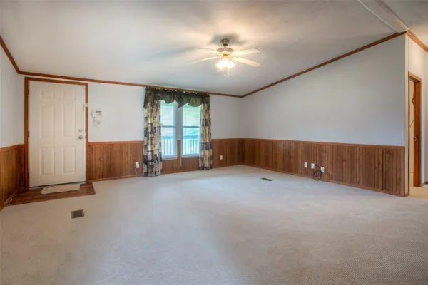 an empty room with windows and ceiling fan