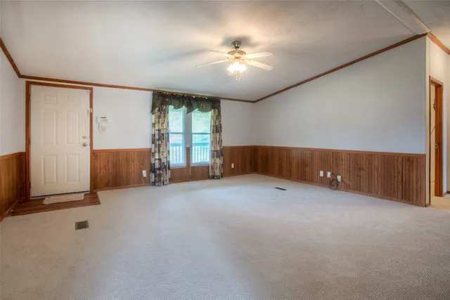 an empty room with windows and ceiling fan