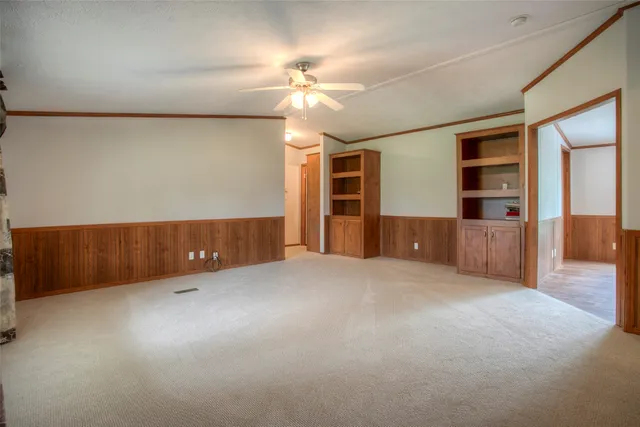 en empty room with windows and ceiling fan