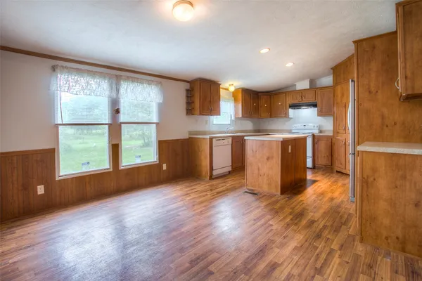 a view of kitchen with stainless steel appliances granite countertop a stove top oven a sink and a refrigerator