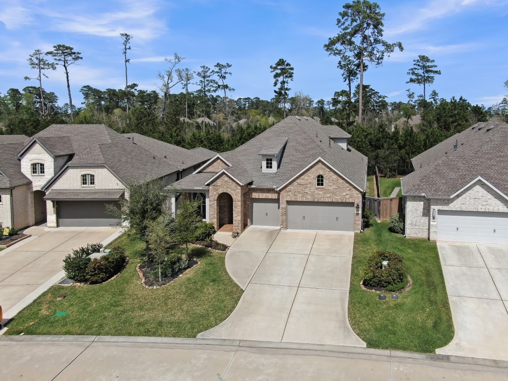 334 Torrey Bloom Loop Conroe, TX 77304 - Photo 2 of 46 Ideally situated on a beautifully landscaped lot with a wide driveway, and serene wooded backdrop offering added privacy.