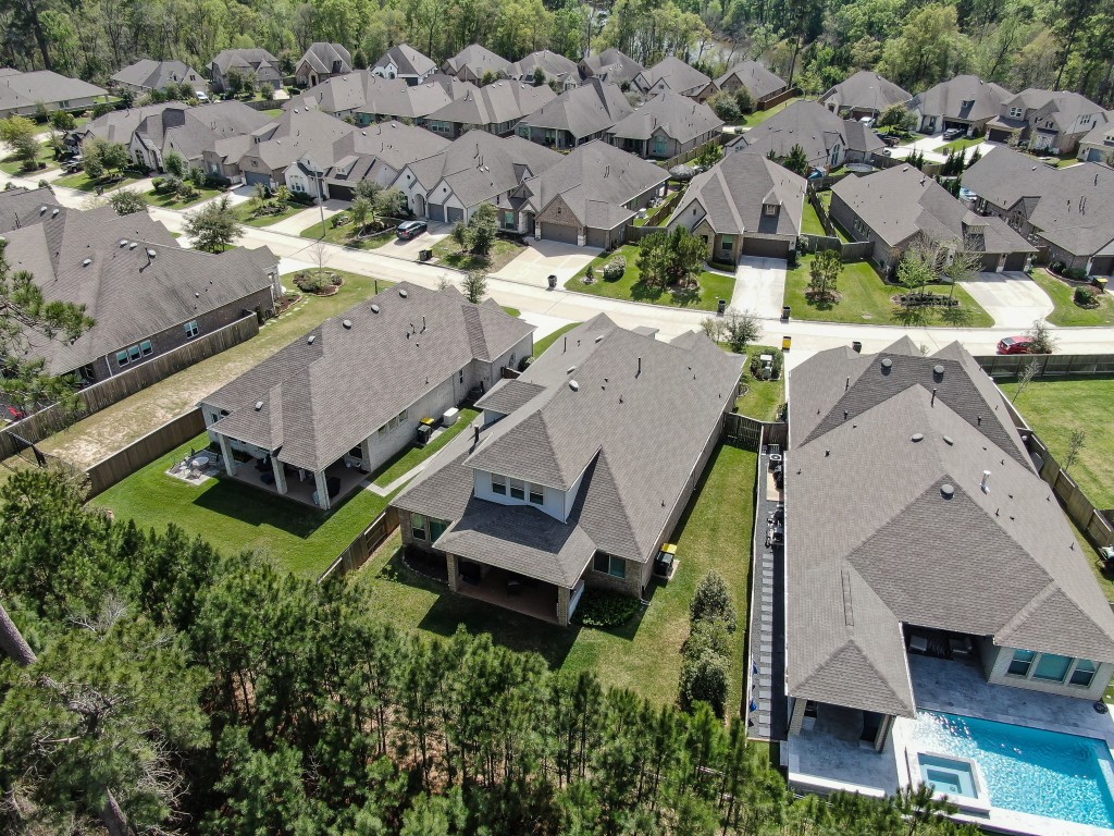 334 Torrey Bloom Loop Conroe, TX 77304 - Photo 39 of 46 Aerial view showcasing a private backyard with no rear neighbors and a serene wooded backdrop in a well-maintained community.