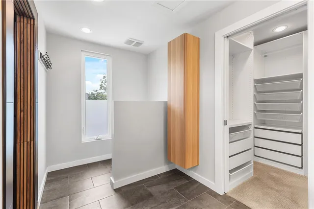 a view of walk in closet with empty racks