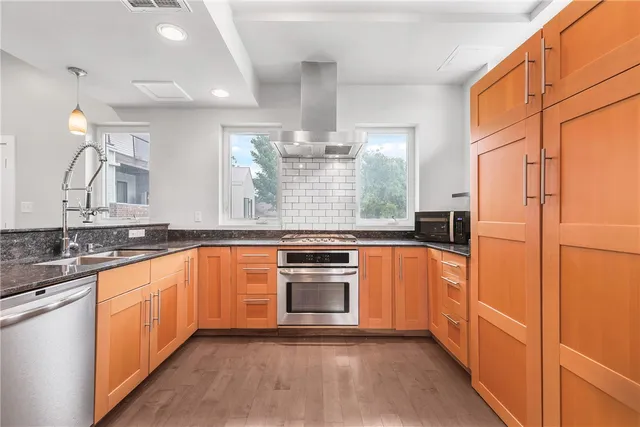 a large kitchen with stainless steel appliances granite countertop a stove and a refrigerator