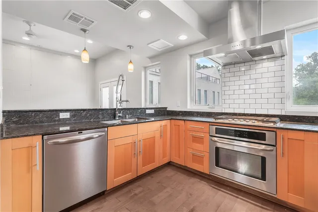 a kitchen with granite countertop stainless steel appliances and wooden cabinets