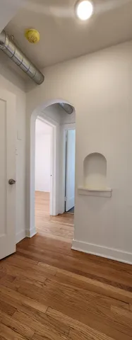 a view of a room with wooden floor and a ceiling fan