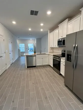 a large kitchen with stainless steel appliances granite countertop a stove and a refrigerator