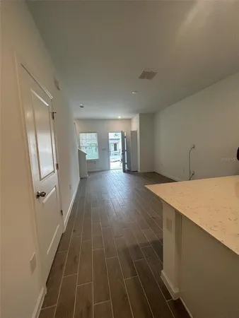 a hallway view with wooden floor and staircase