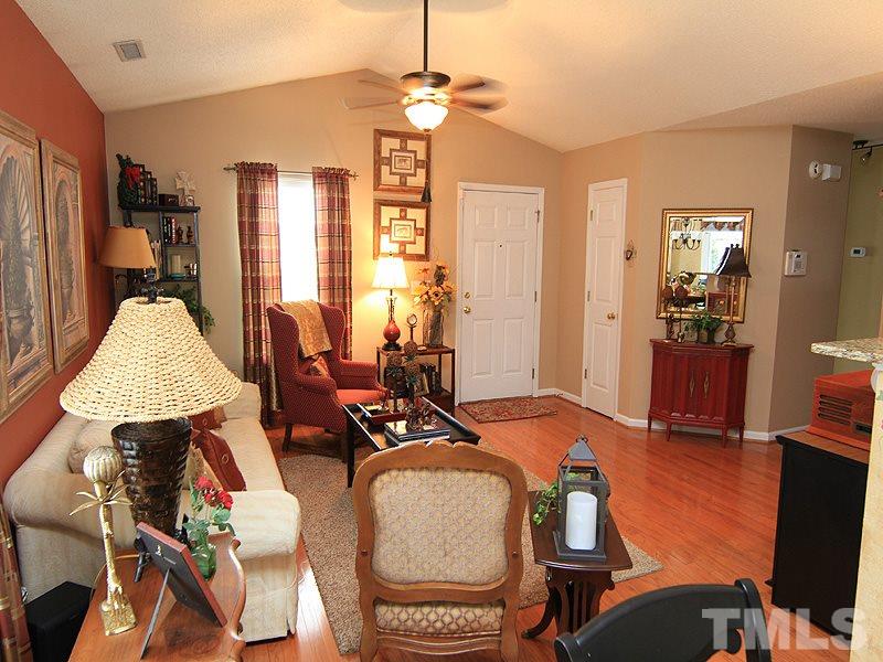 5121 Silverdene Street Raleigh, NC 27616 - Photo 3 of 12 a living room with furniture a chandelier and a flat screen tv