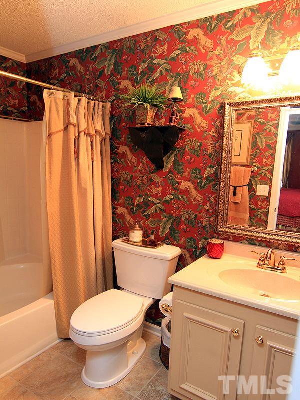 5121 Silverdene Street Raleigh, NC 27616 - Photo 7 of 12 a bathroom with a sink a toilet and shower curtain