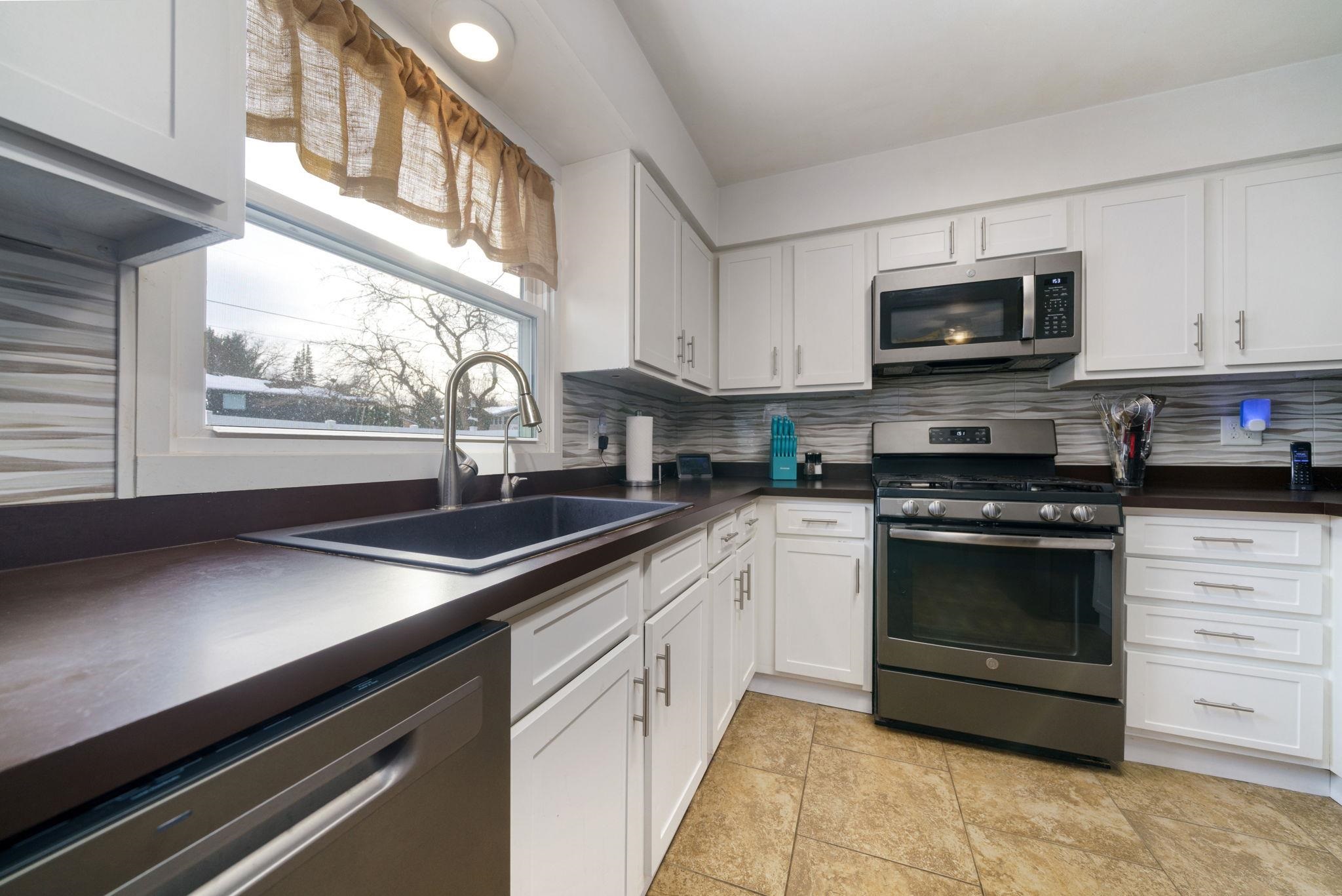5393 Lakecrest Road Caledonia, IL 61011 - Photo 14 of 40 a kitchen with stainless steel appliances a stove microwave and a sink