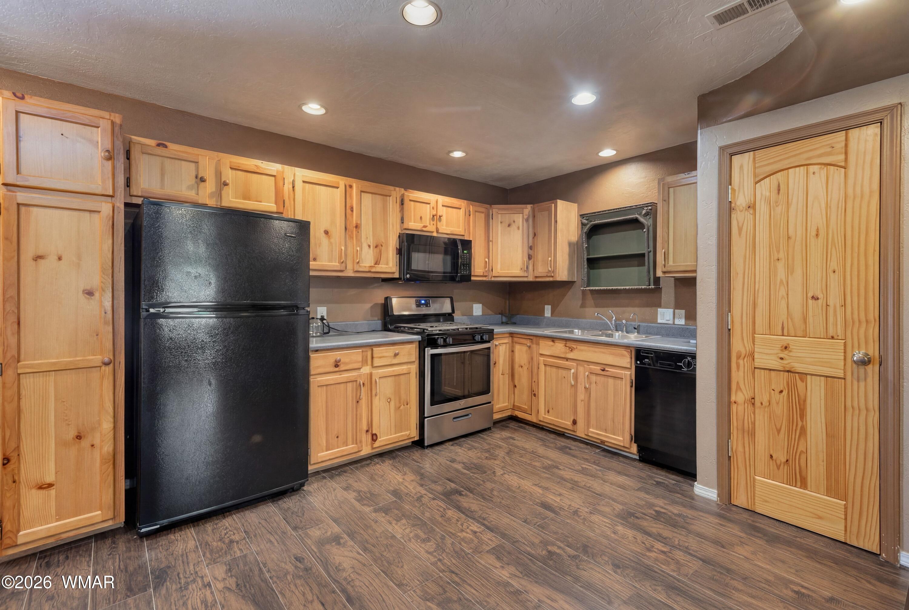 2722 Bain Trail Overgaard, AZ 85933 - Photo 5 of 28 a kitchen with stainless steel appliances granite countertop a refrigerator a sink dishwasher a stove and a refrigerator with wooden floor