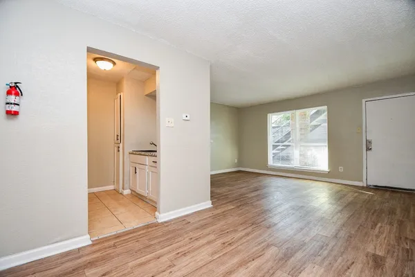 an empty room with wooden floor and a window