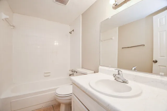 a bathroom with a toilet a sink a mirror and a bathtub