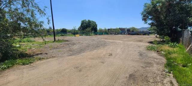 a view of a dirt road with a building in the background