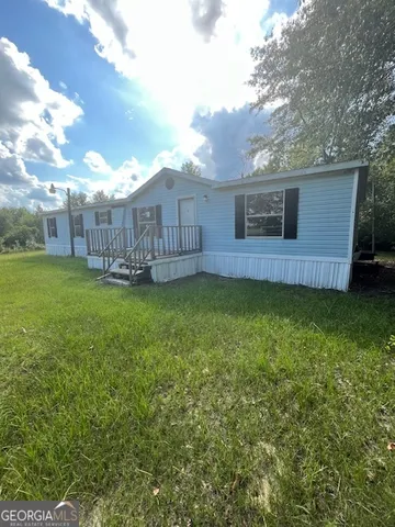 a view of a backyard with a garden and wooden fence