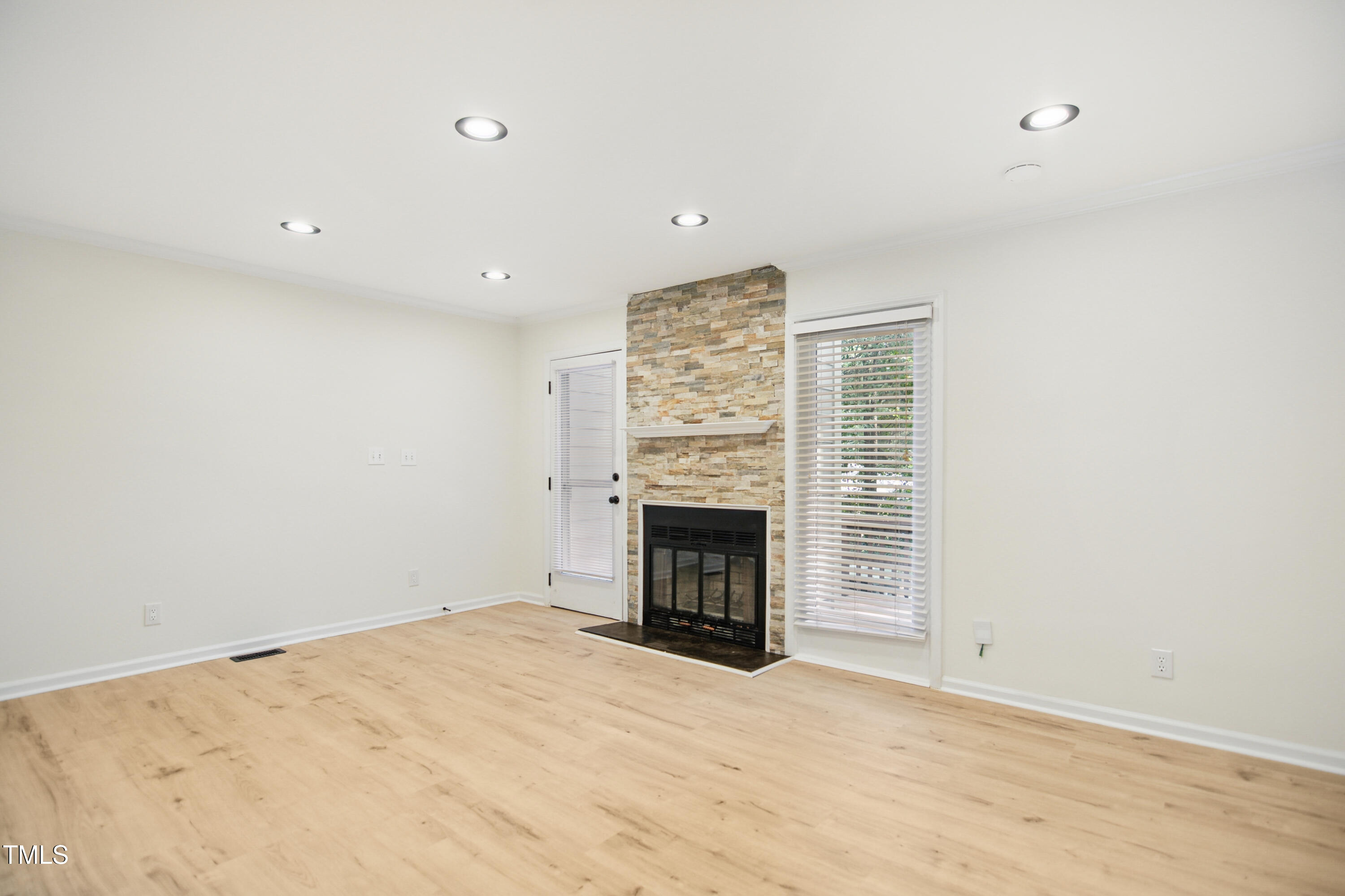 5436 Sharpe Drive Raleigh, NC 27612 - Photo 3 of 18 an empty room with a fireplace and cabinet