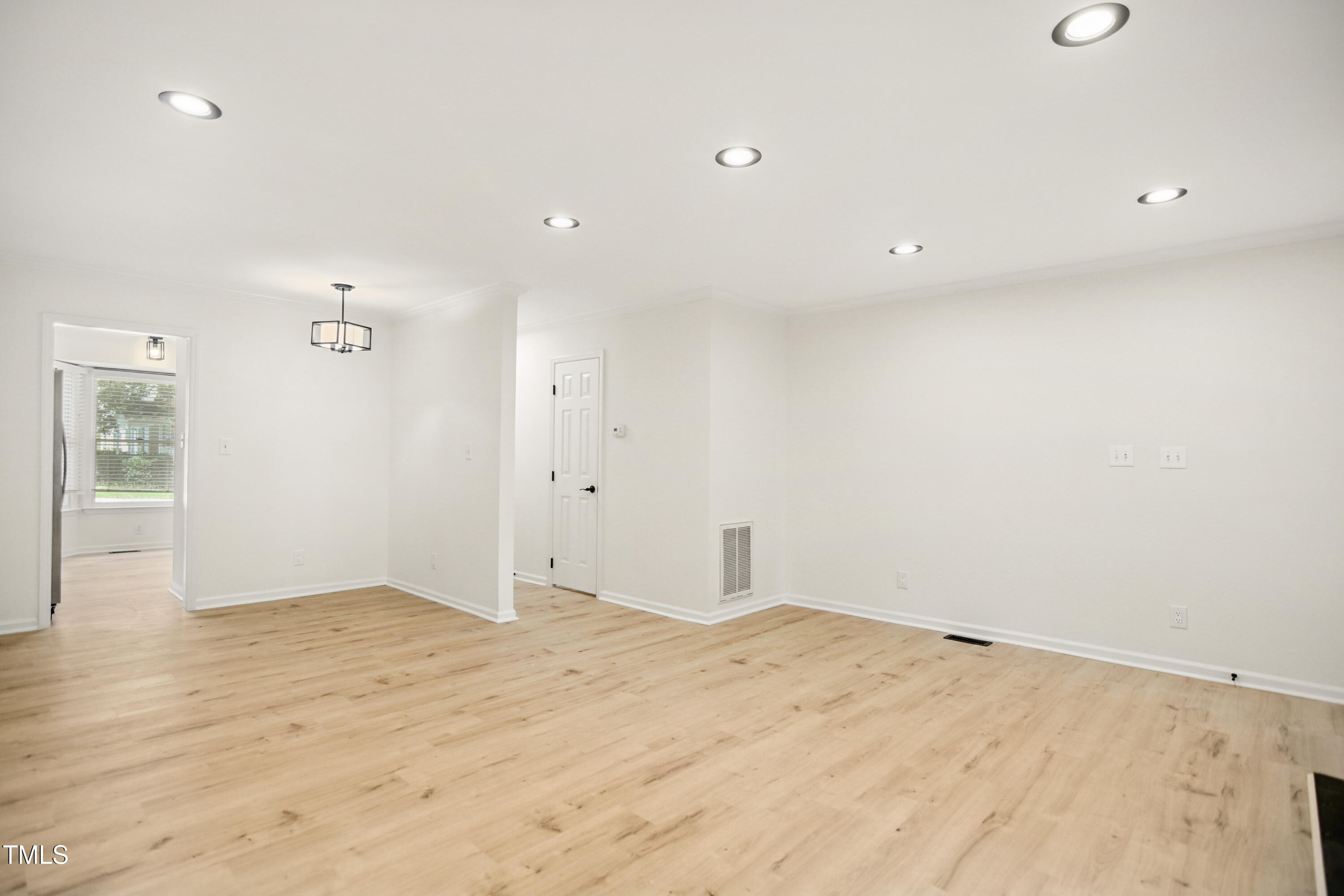 5436 Sharpe Drive Raleigh, NC 27612 - Photo 4 of 18 an empty room with wooden floor and windows
