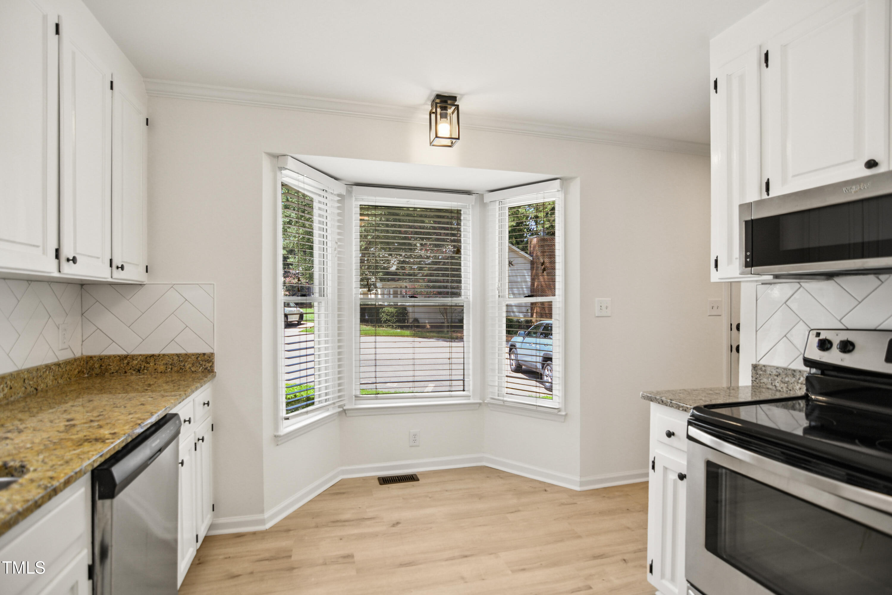 5436 Sharpe Drive Raleigh, NC 27612 - Photo 6 of 18 a kitchen with granite countertop a stove and a sink