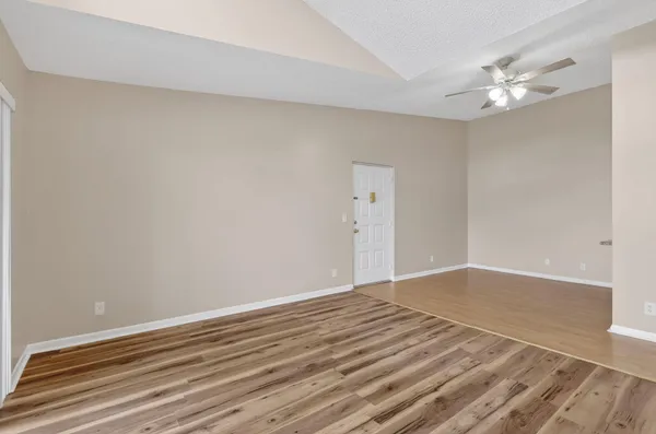 a view of an empty room with wooden floor