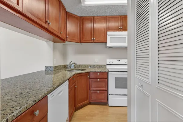a kitchen with granite countertop a sink and cabinets