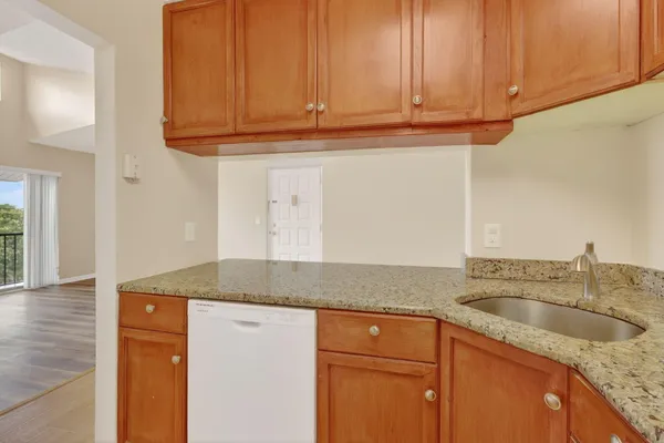 a kitchen with granite countertop a sink and cabinets
