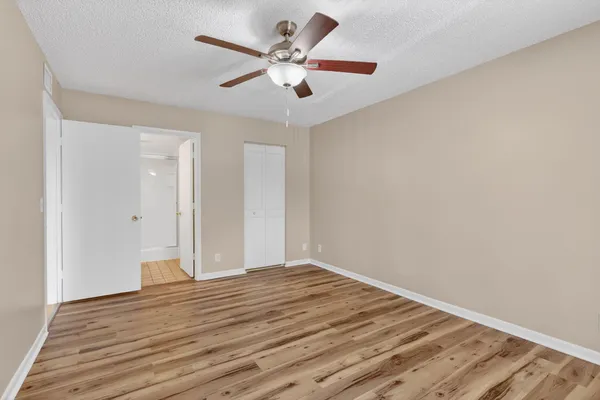 a view of a room with wooden floor and a ceiling fan