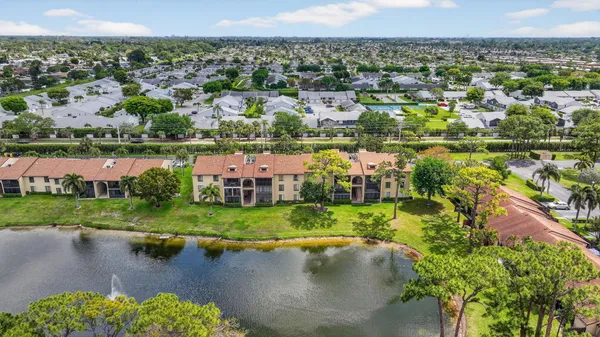 an aerial view of a house with a garden and lake view