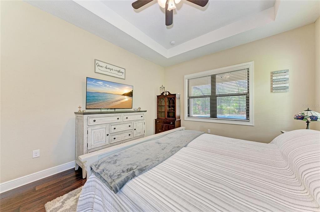 12642 Harney Street Venice, FL 34293 - Photo 25 of 85 a bedroom with a bed and a flat screen tv
