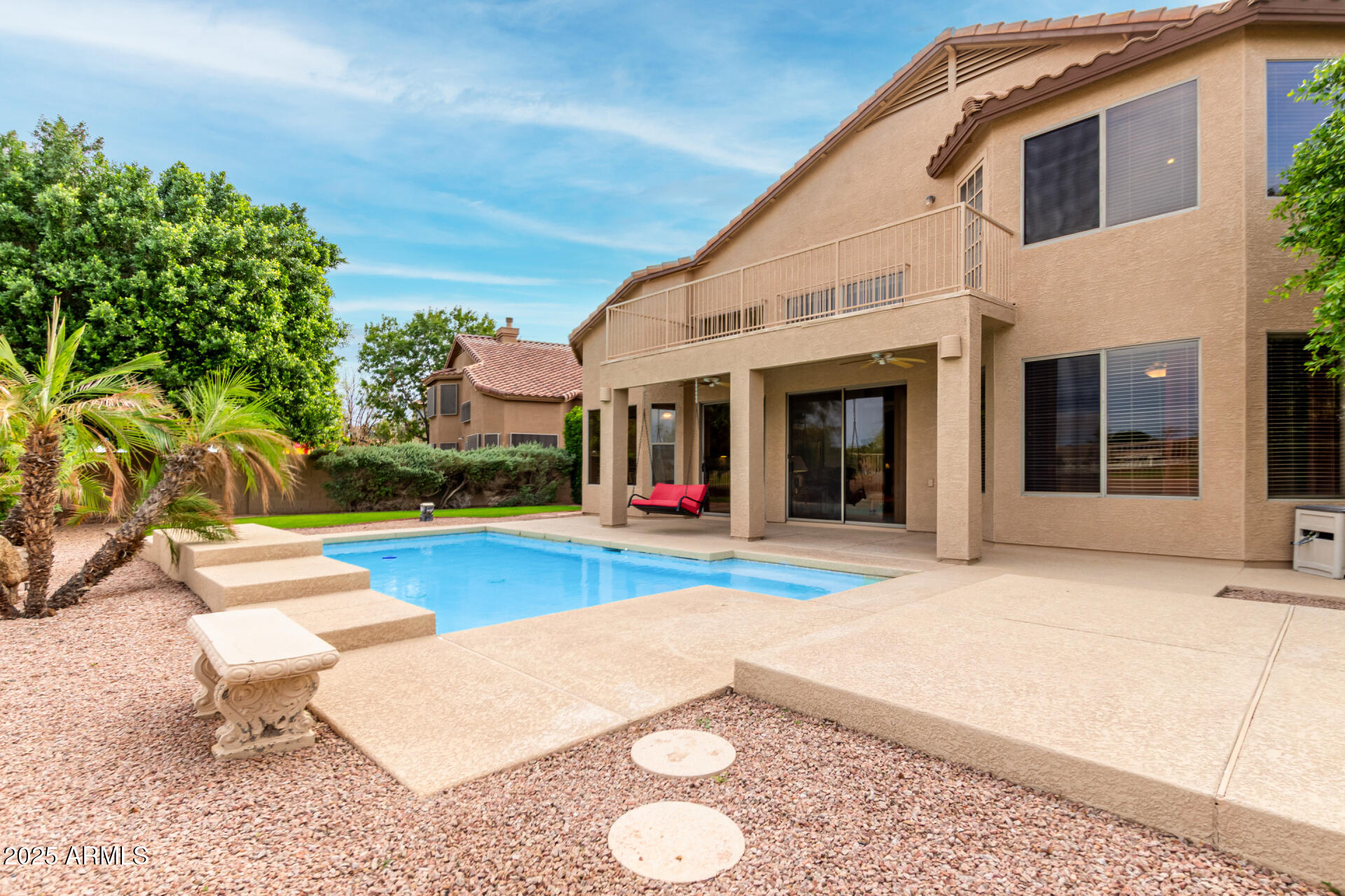 1111 South Sandstone Street Gilbert, AZ 85296 - Photo 42 of 59 a view of a white house with swimming pool lawn chairs and a yard