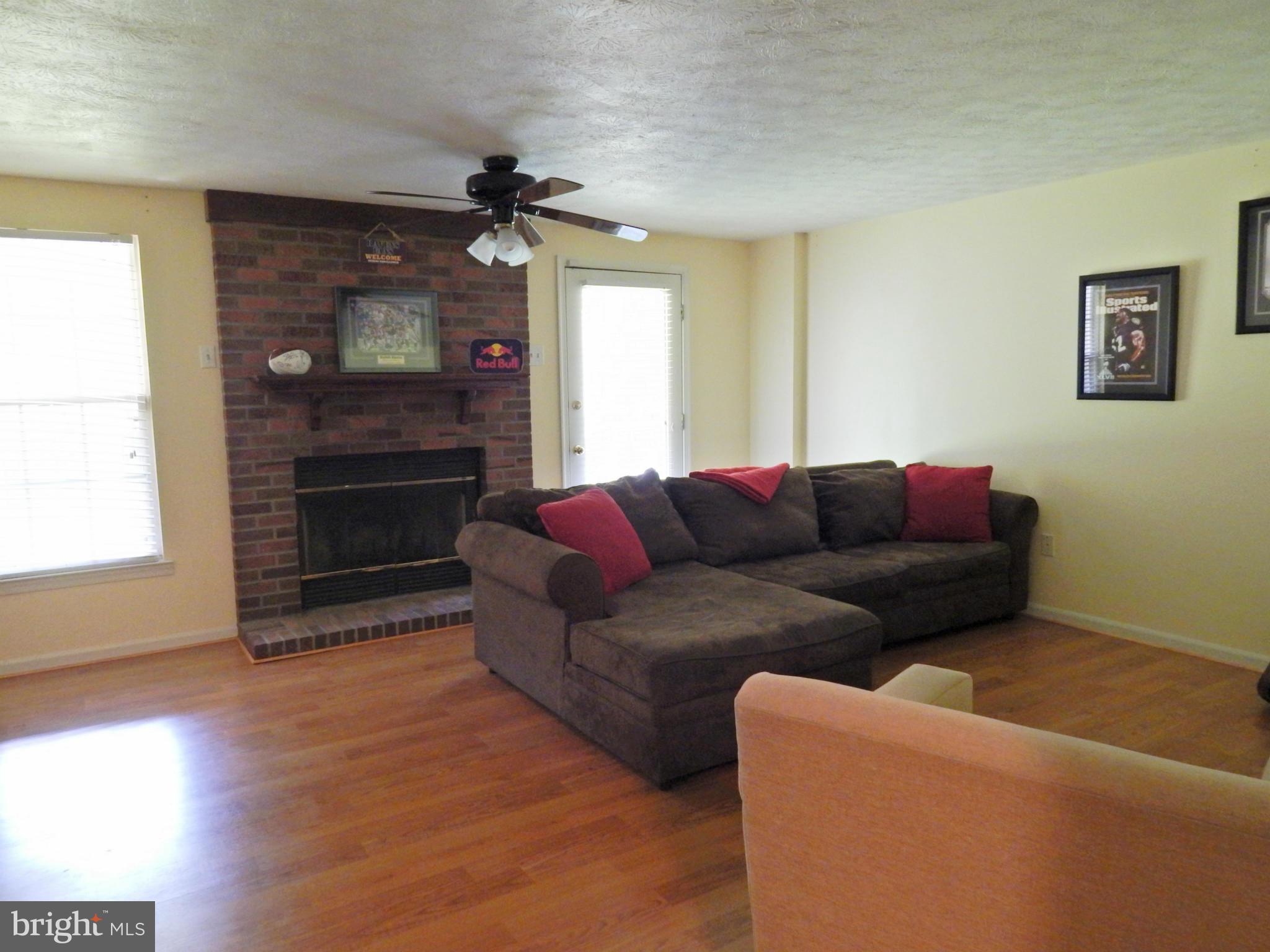 7799 Paddock Way Baltimore, MD 21244 - Photo 27 of 27 a living room with furniture a fireplace and a flat screen tv