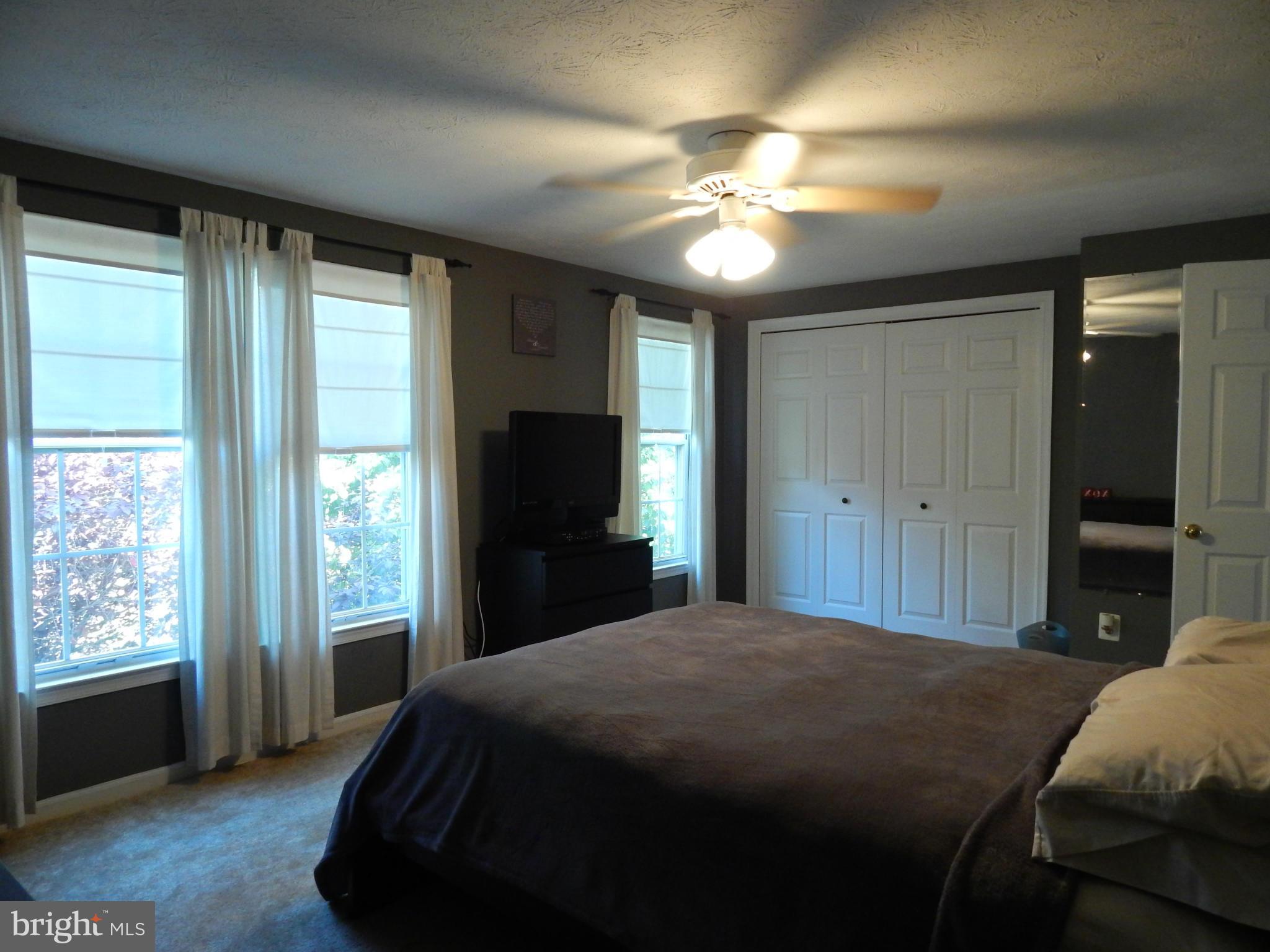 7799 Paddock Way Baltimore, MD 21244 - Photo 8 of 27 a bedroom with a large bed and a chandelier