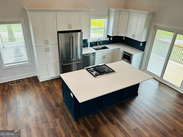 a kitchen with a refrigerator sink and wooden floor