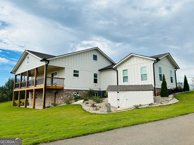 a view of house with a yard and deck