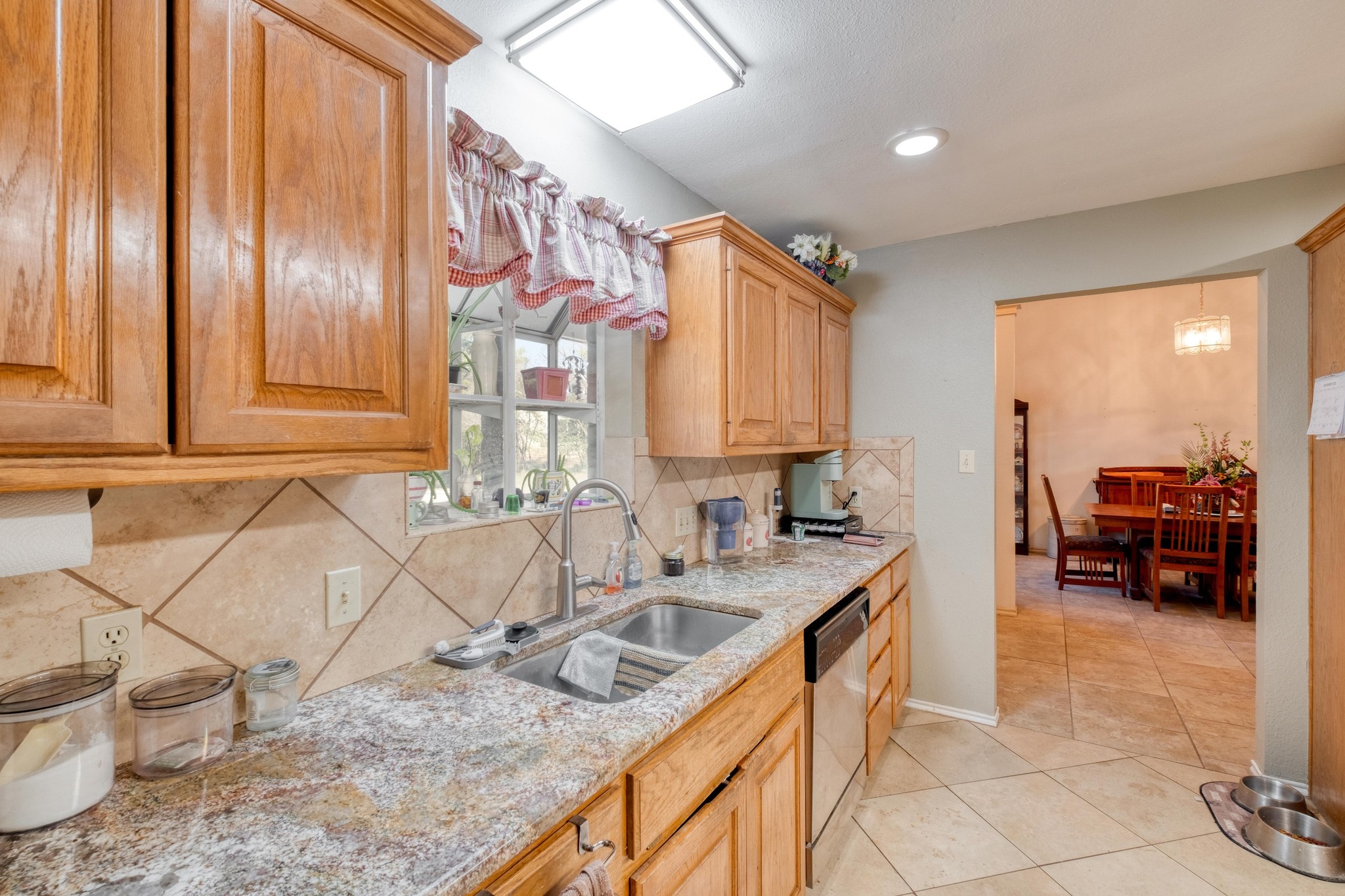 153 Pleasant Grove Road Elgin, TX 78621 - Photo 15 of 34 Kitchen with backsplash, light tile patterned flooring, light stone counters, dishwasher, and recessed lighting