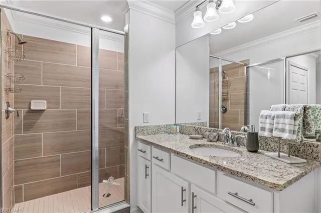 a bathroom with a granite countertop sink a mirror and a shower