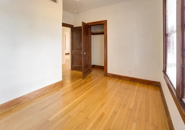 an empty room with wooden floor and a window