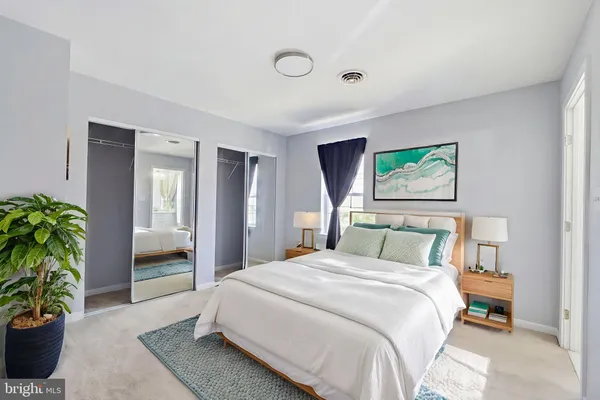 a bedroom with a bed and a potted plant