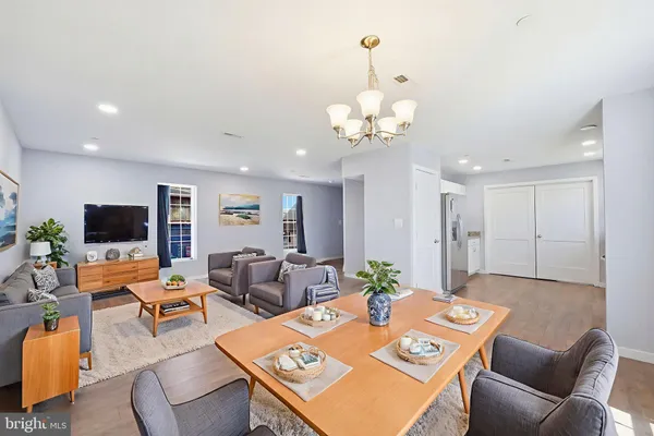 a living room with furniture a flat screen tv and kitchen view