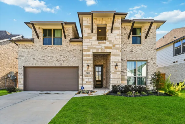 a front view of a house with a garden and yard