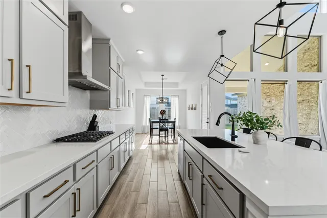 a kitchen with sink a stove and cabinets