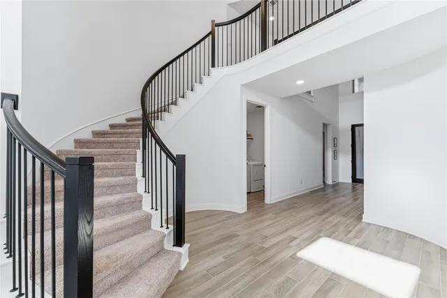 a view of staircase with white walls and railing