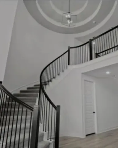 a view of staircase with railing and white walls