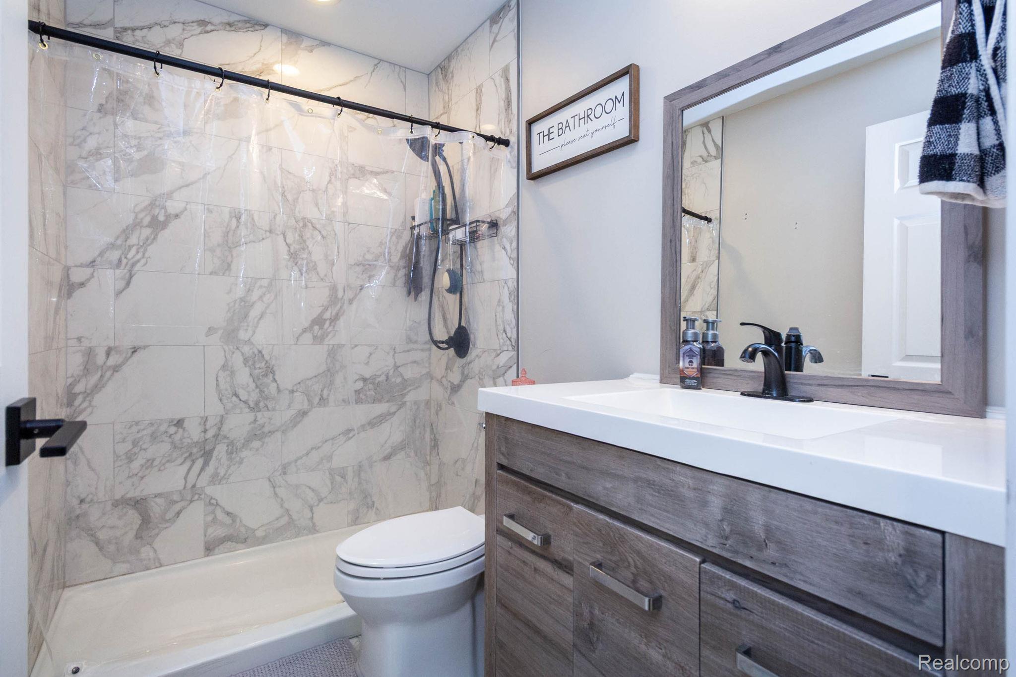 2559 Harrison Avenue Rochester, MI 48307 - Photo 17 of 32 Bathroom shower with marble-look tile surround