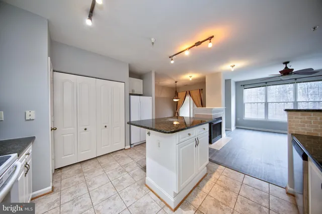 a kitchen with stainless steel appliances kitchen island granite countertop a sink and cabinets