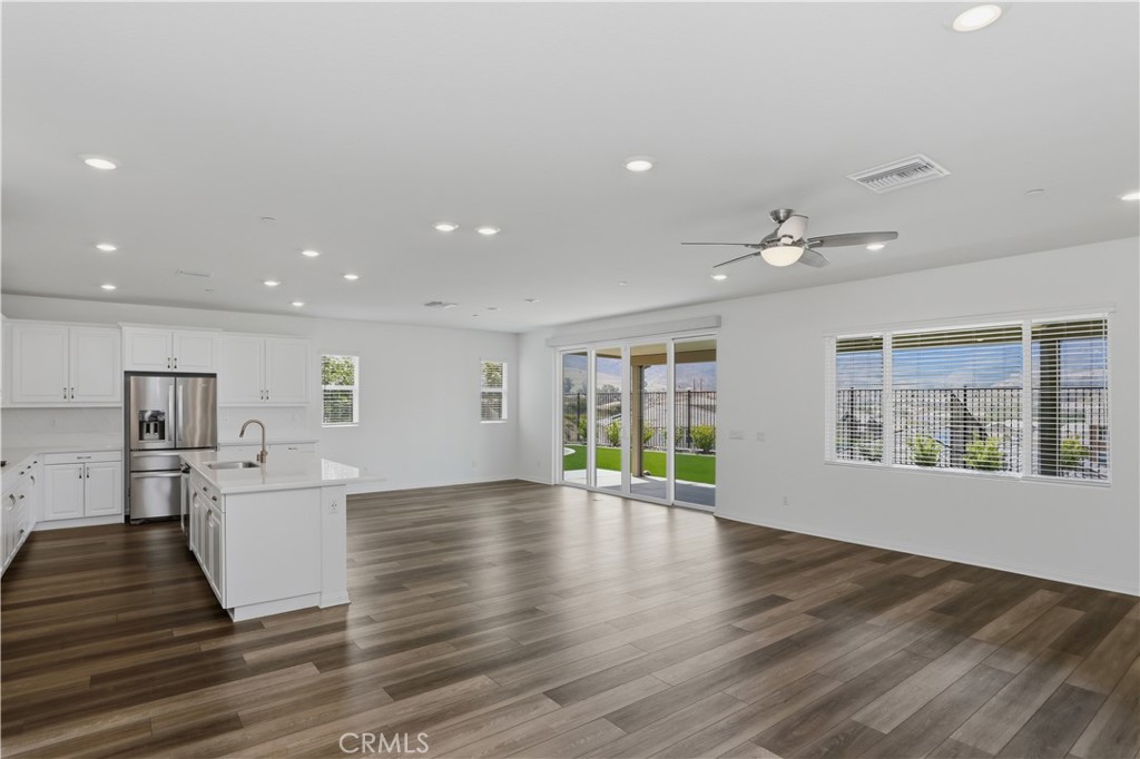 21159 Blue Jeans Court Riverside, CA 92507 - Photo 28 of 63 a view of an empty room with wooden floor and a kitchen